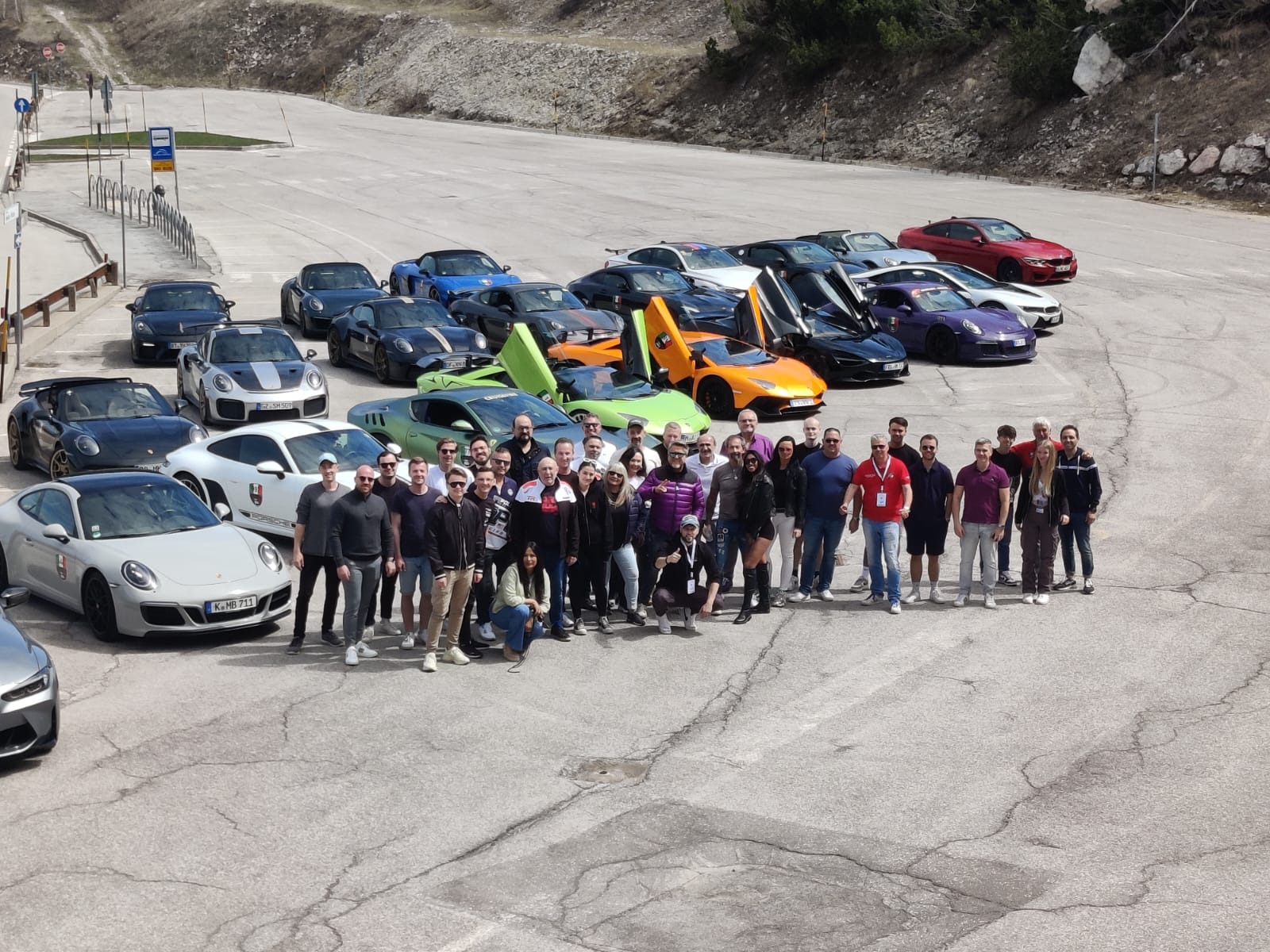 LagoRun participants with their sports cars against a mountain backdrop